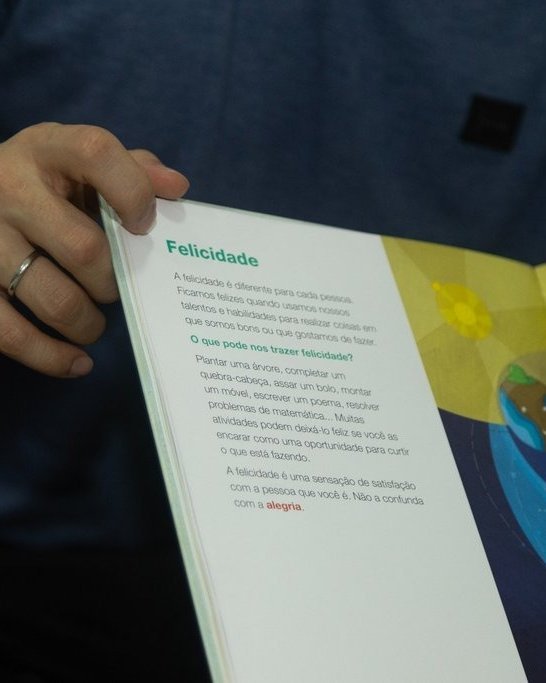 Livro sobre sentimentos aberto na página Felicidade durante uma sessão